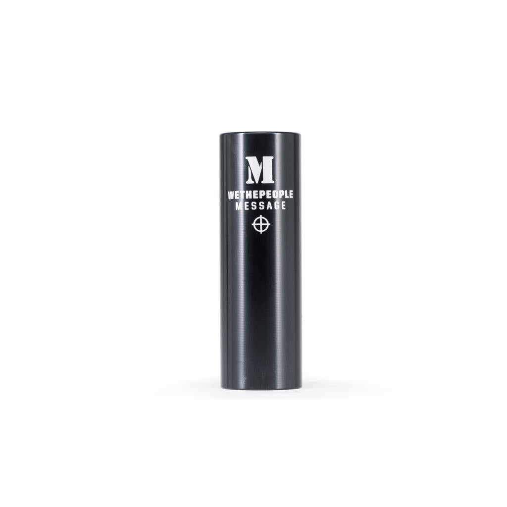 A pair of black cylindrical Wethepeople Message Alloy Pegs, featuring "WETHEPEOPLE MESSAGE" and a crosshair symbol engraved, made from lightweight 7075-T6 alloy—perfect BMX skatepark pegs shown upright on a white background.