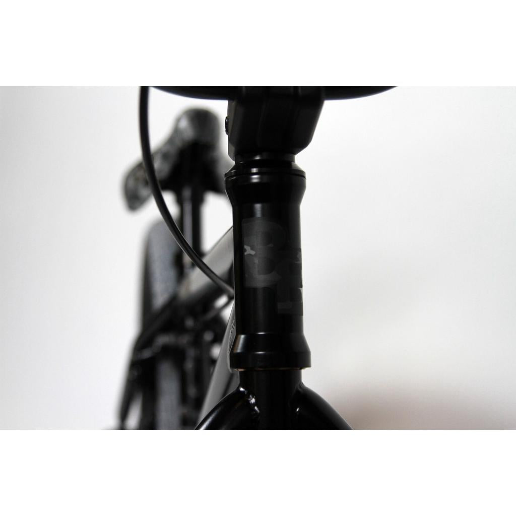 Close-up of the Black Eye Commando 20 Inch Bike (2022) front head tube and handlebars against a white backdrop—an ideal entry-level BMX option with standout style.