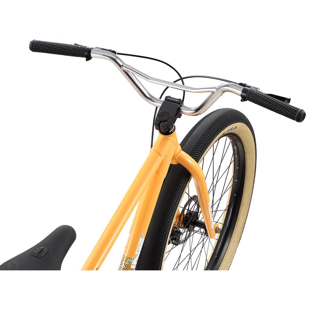 Close-up of the handlebars, front wheel, and frame of a Redline RL 275 27.5 Inch Bike in orange with black grips and beige sidewall tires.