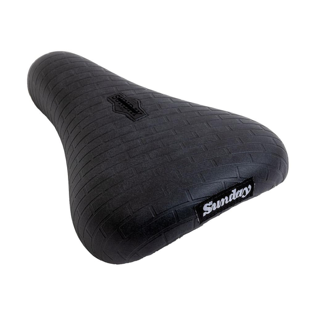 The Sunday Pivotal Seat (Brett Silva Signature) features a textured, brick-like tread pattern with "Sunday" logos, designed for comfort and durability using Pivotal technology and inspired by Brett Silva’s unique style.
