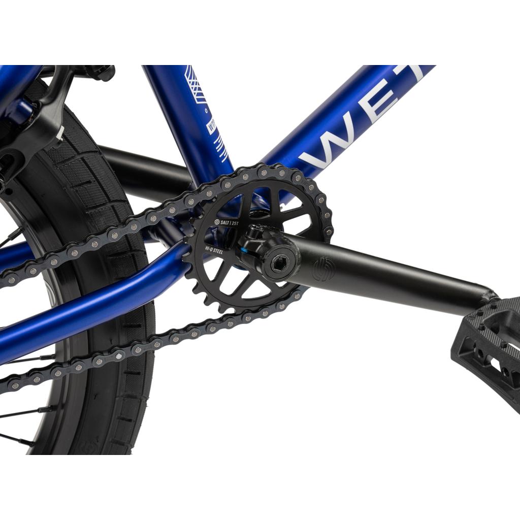 Close-up of the Wethepeople CRS FC 20 Inch Bike's blue drivetrain, featuring the chain, chainring, crank arm, pedal, and a freecoaster hub.