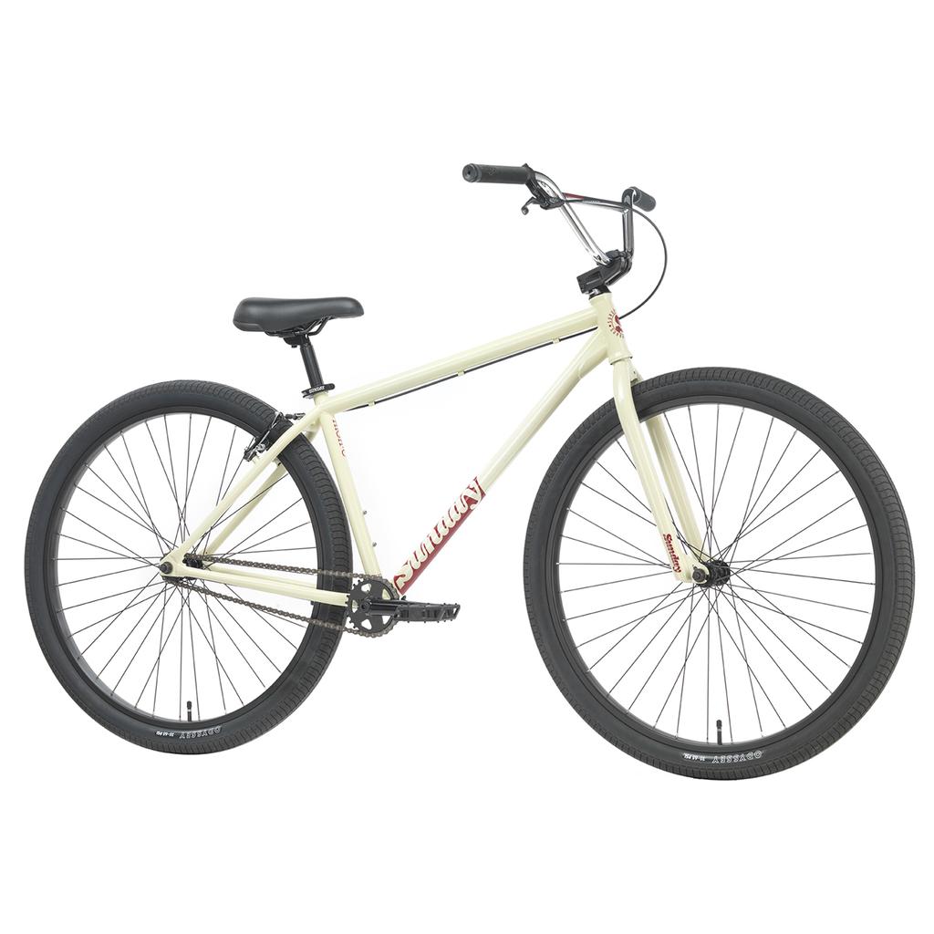 A cream-colored Sunday High C Bike (2026) with a 29" full chromoly frame, black tires, a black seat, and upright handlebars is shown from the side against a white background.