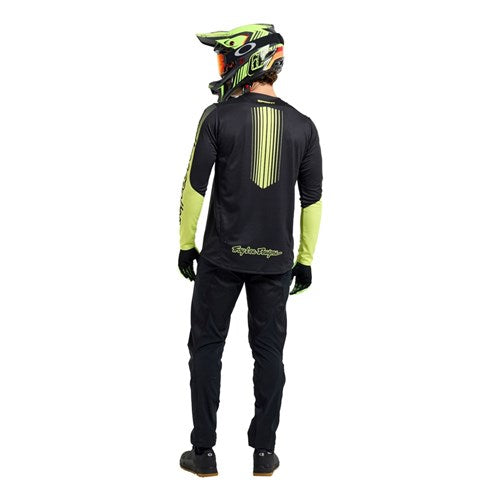 Individual in a TLD 25.2 Sprint Jersey / Segment Black and helmet, facing away from the camera against a white background.