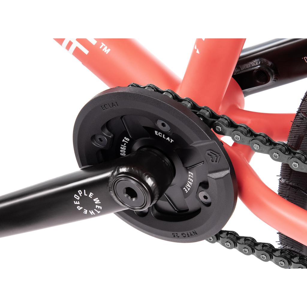 Close-up of a BMX crankset showcasing the Eclat Elevate Guard Sprocket with visible crank arm, chain, Nylon Fiberglass bash guard, and orange bike frame.