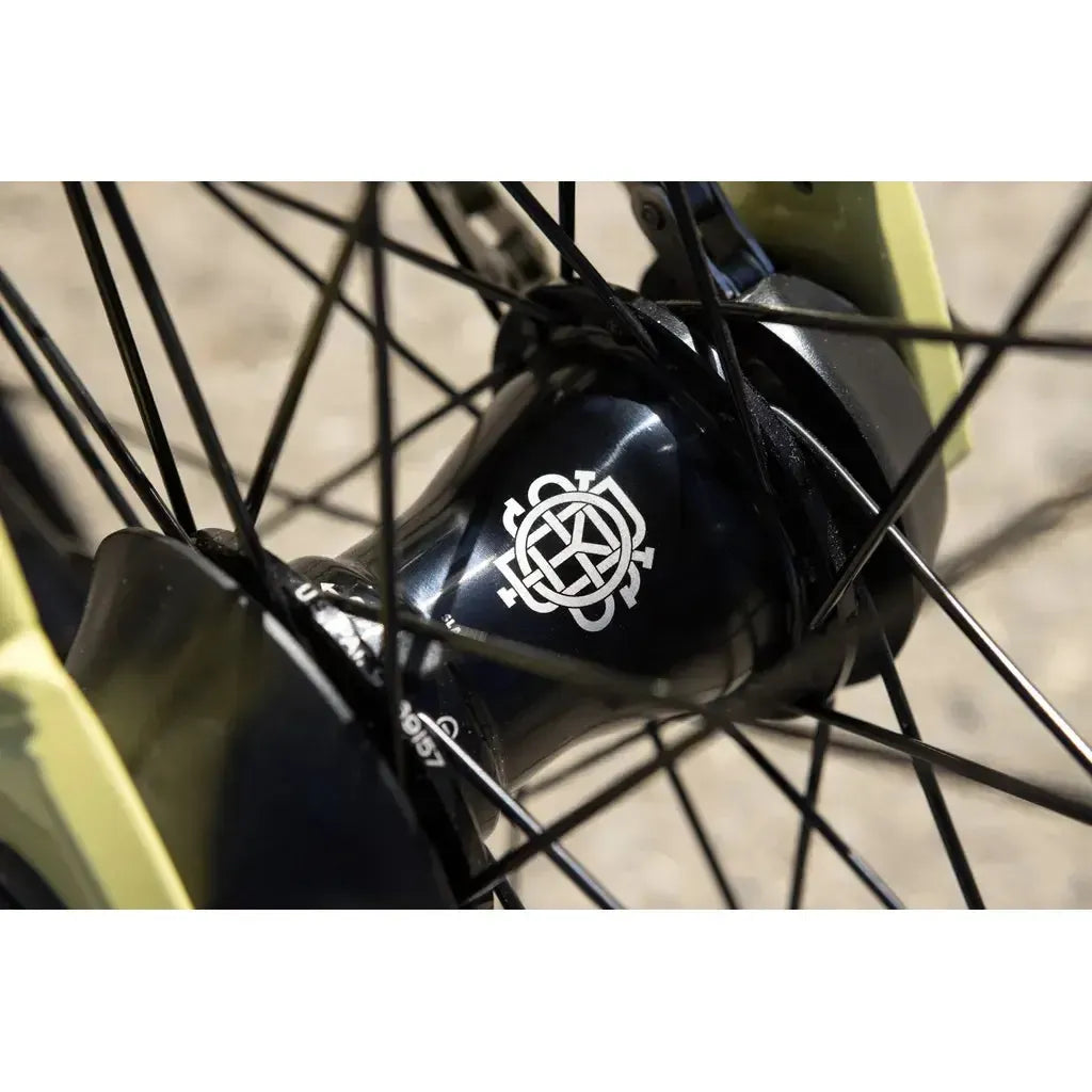Close-up of a black hub with a white geometric logo, black spokes, and yellow fork on the Sunday Soundwave Special Bike (2025) featuring Odyssey parts covered by their 41-Thermal Lifetime Warranty.