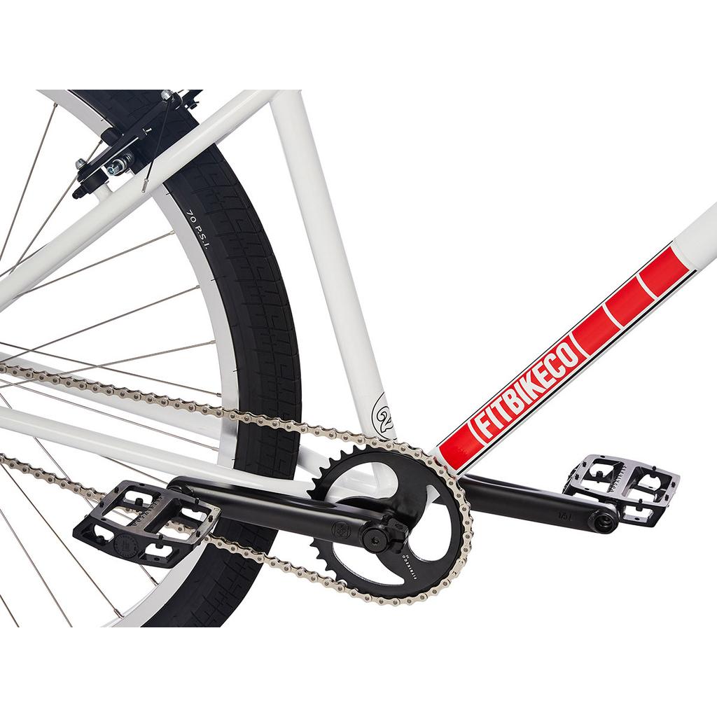 Close-up of the Fit CR29 Inch Bike (2023) drivetrain with chain, pedals, crankset, rear wheel, and "FITBIKECO" branding on this 29-inch BMX cruiser.