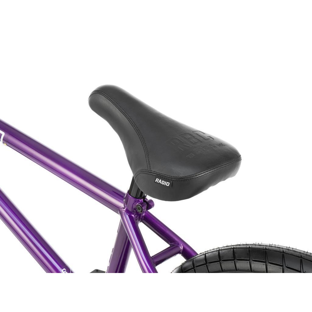 Close-up of a black seat on the Radio Darko 20 Inch Bike, featuring a metallic purple frame made from durable chromoly, with part of the rear tire visible.