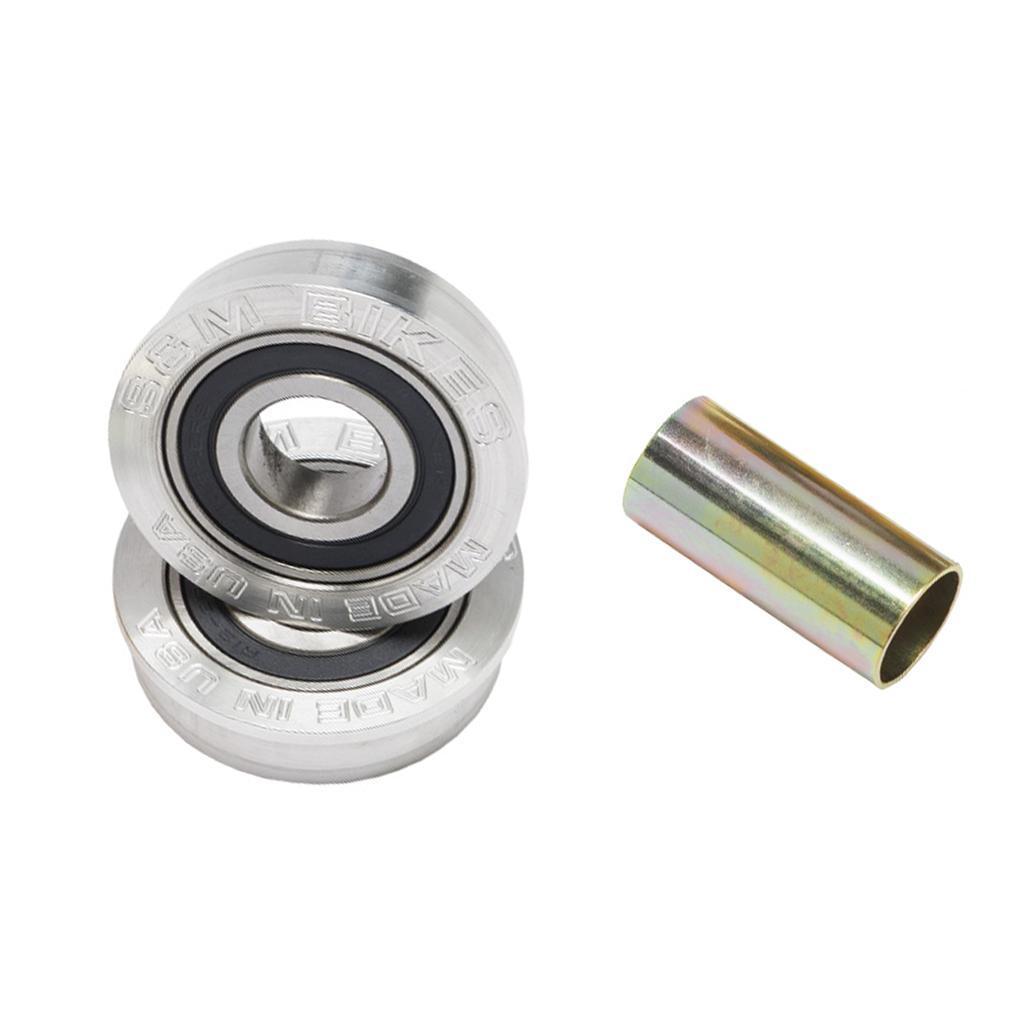 Two metal ball bearings are stacked beside a cylindrical spacer—components from the S&M USA Bottom Bracket Set for BMX—displayed on a white background.