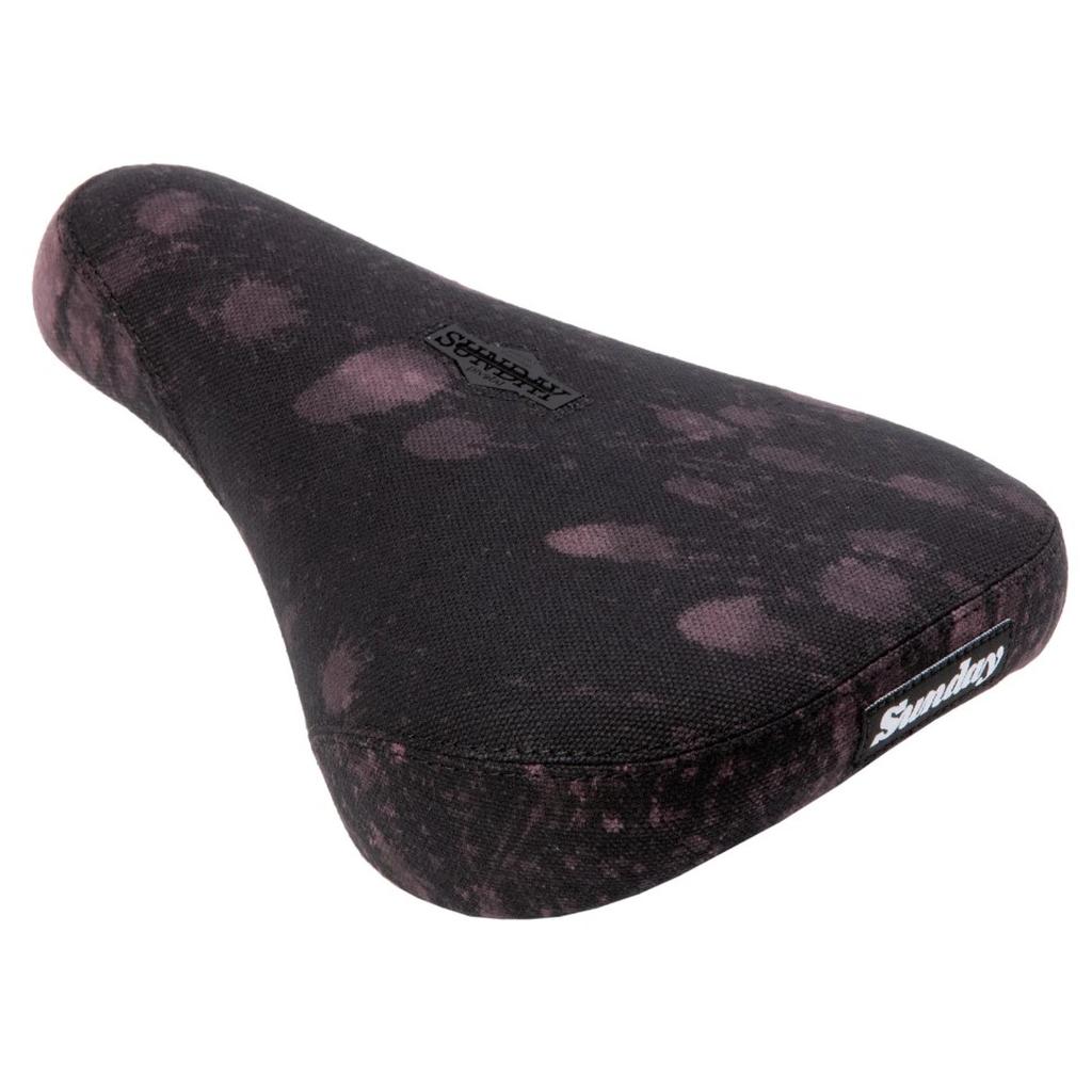 The Sunday Bleached Pivotal Seat (Brett Silva Signature) is a black BMX seat with subtle pink splotches and "Shadow" logos on top and front, designed in collaboration with pro rider Brett Silva.