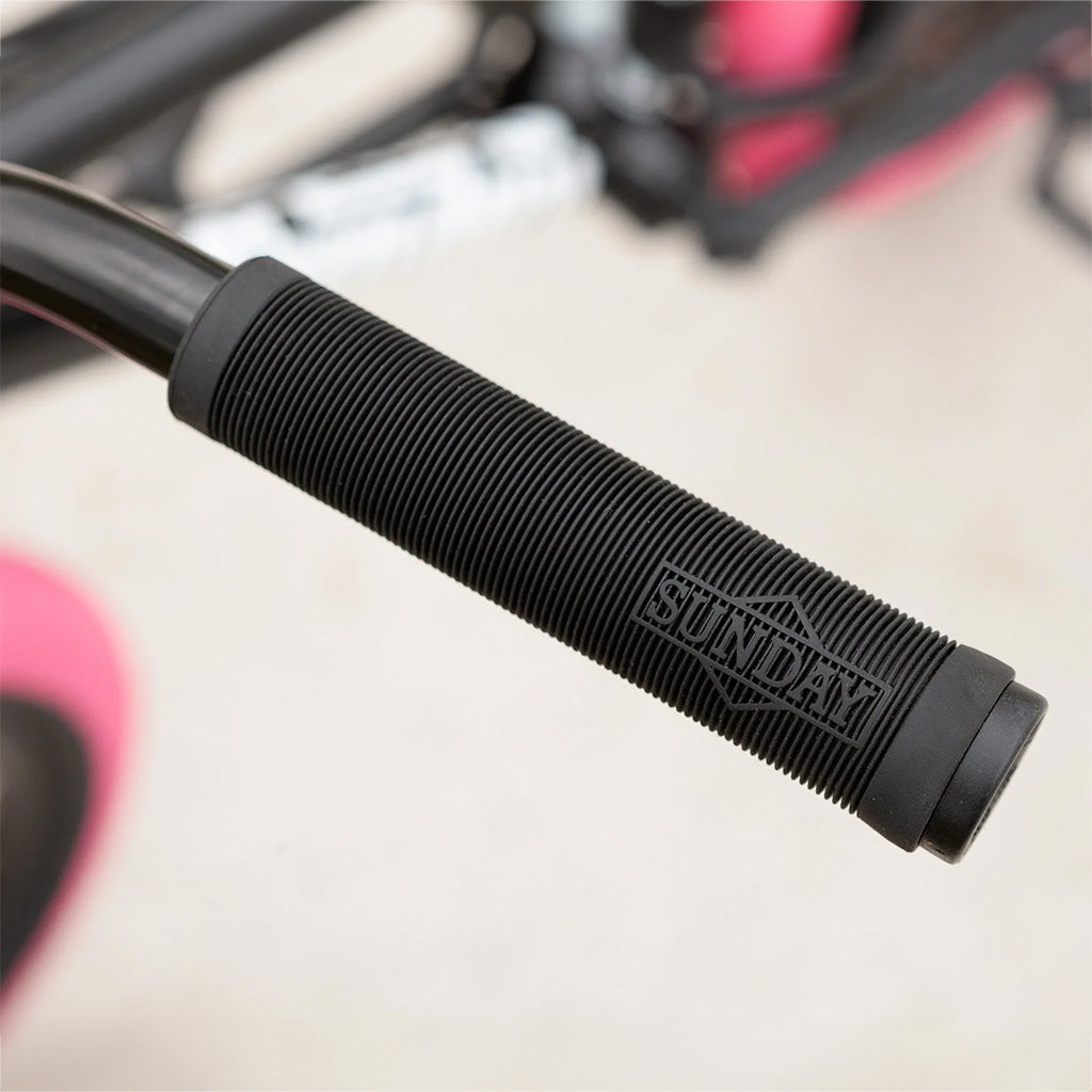 A close up of a pink BMX handlebar on a Sunday Blueprint 20 inch Bike.