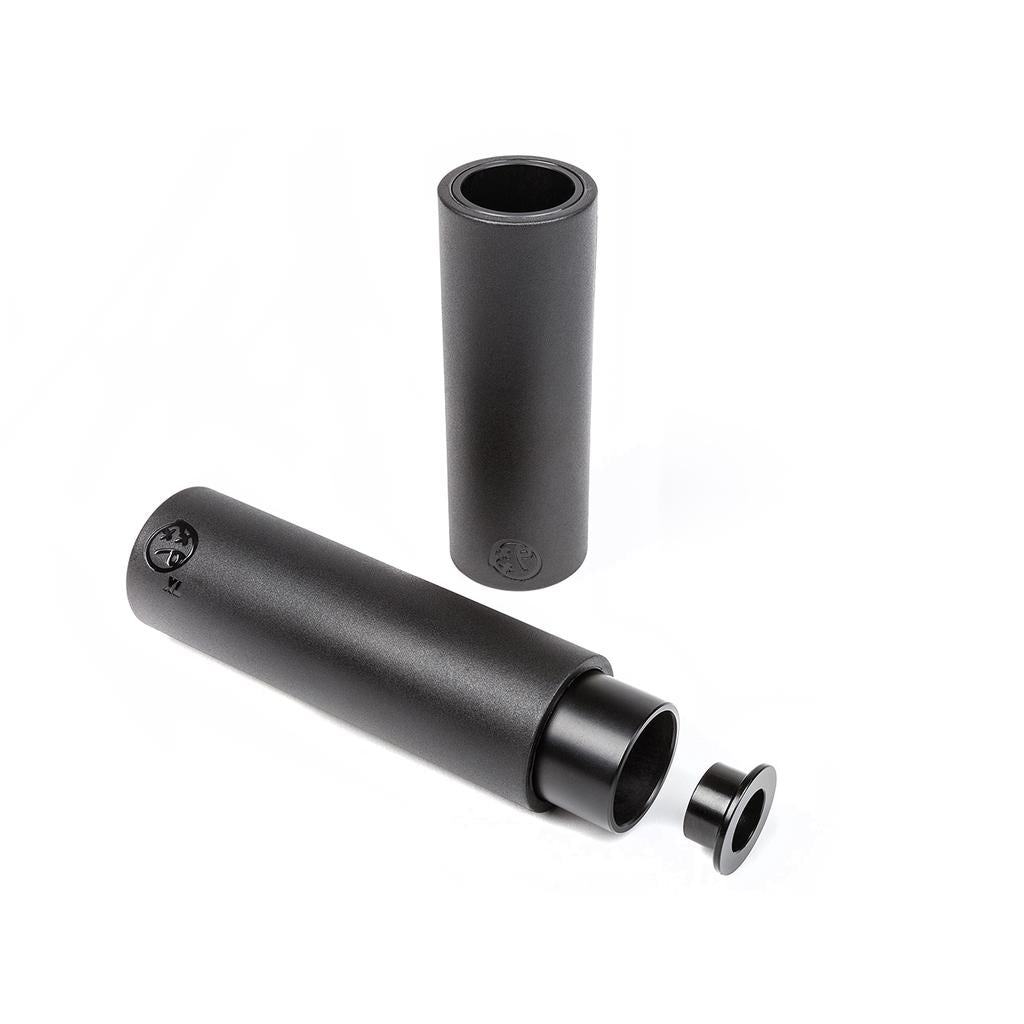 Two BSD Rude Tube LT V2 Plastic Pegs (black), one upright and one lying down with its cap and inner section partly removed, are shown on a white background. Lightweight pegs ideal for BMX street or park riding.