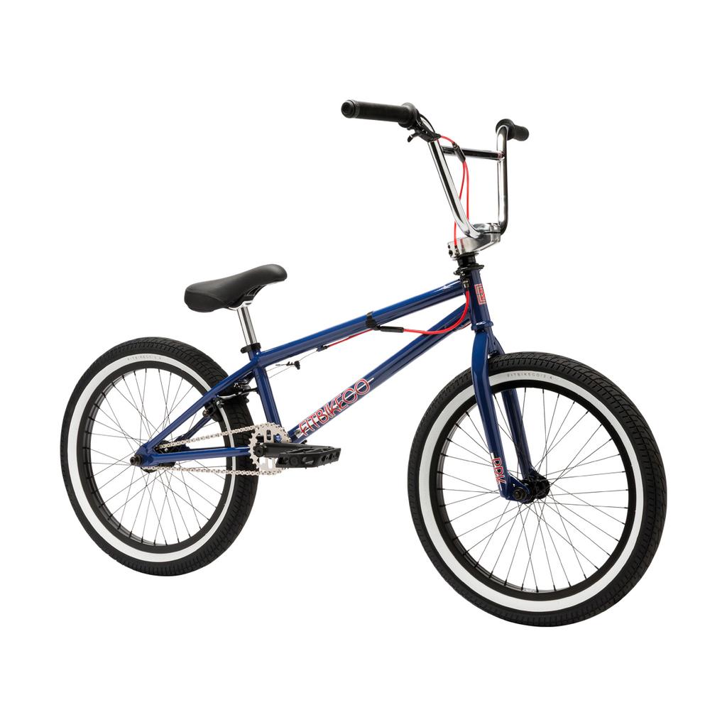 The Fit Bike Co PRK 20 Inch Bike is a blue BMX park bike featuring a short top tube, black tires, silver spokes, black handlebars, and red brake cables, shown on a white background.