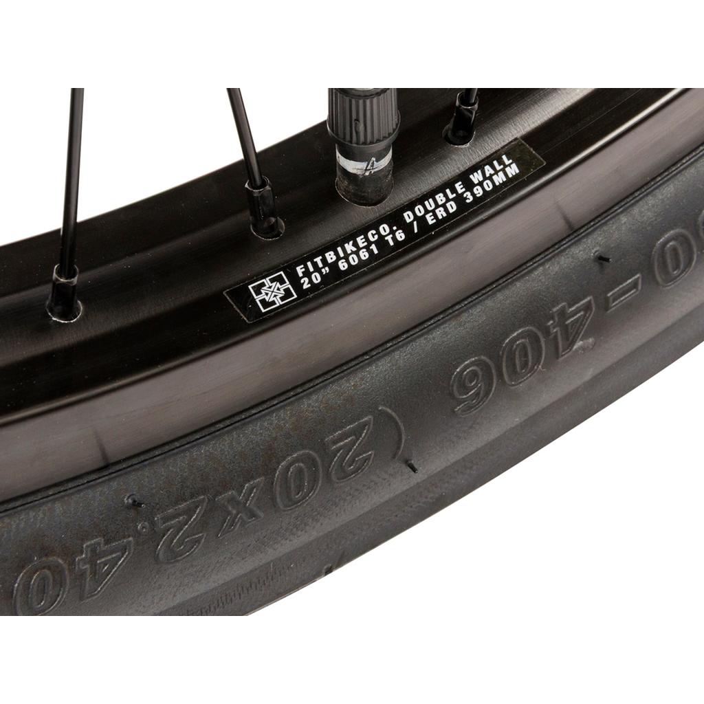 Close-up of a Fit Bike Co STR 20 Inch Bike (2026) wheel, showcasing its black double-wall rim, street-ready tire tread, visible valve stem, and printed rim specs.