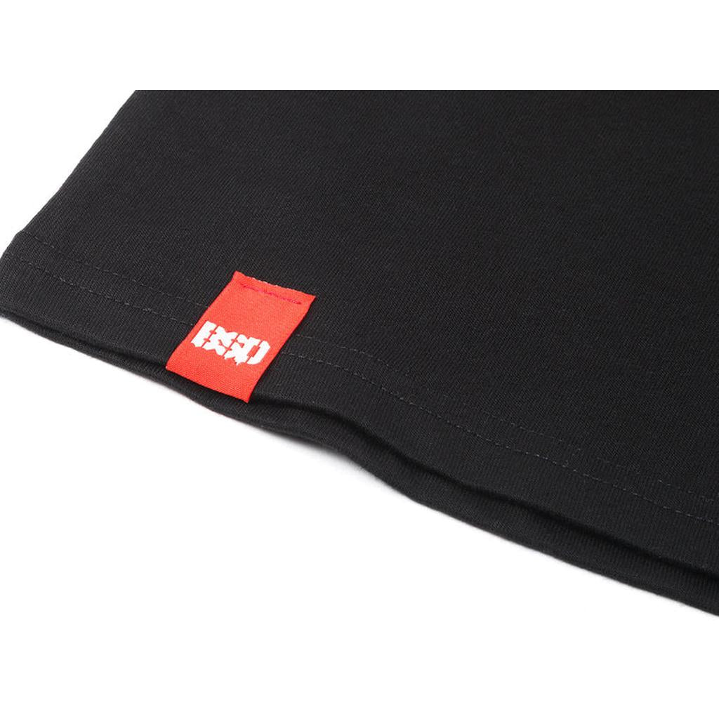 Close-up of the hem of a BSD Wobbler T-Shirt, showing a red fabric tag with a white graphic logo.