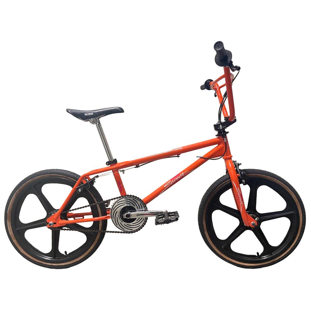 The Skyway Street Beat 20 Inch Bike, with a red 4130 chromoly frame, black mag wheels, black seat, and visible gear mechanism, is displayed against a white background.