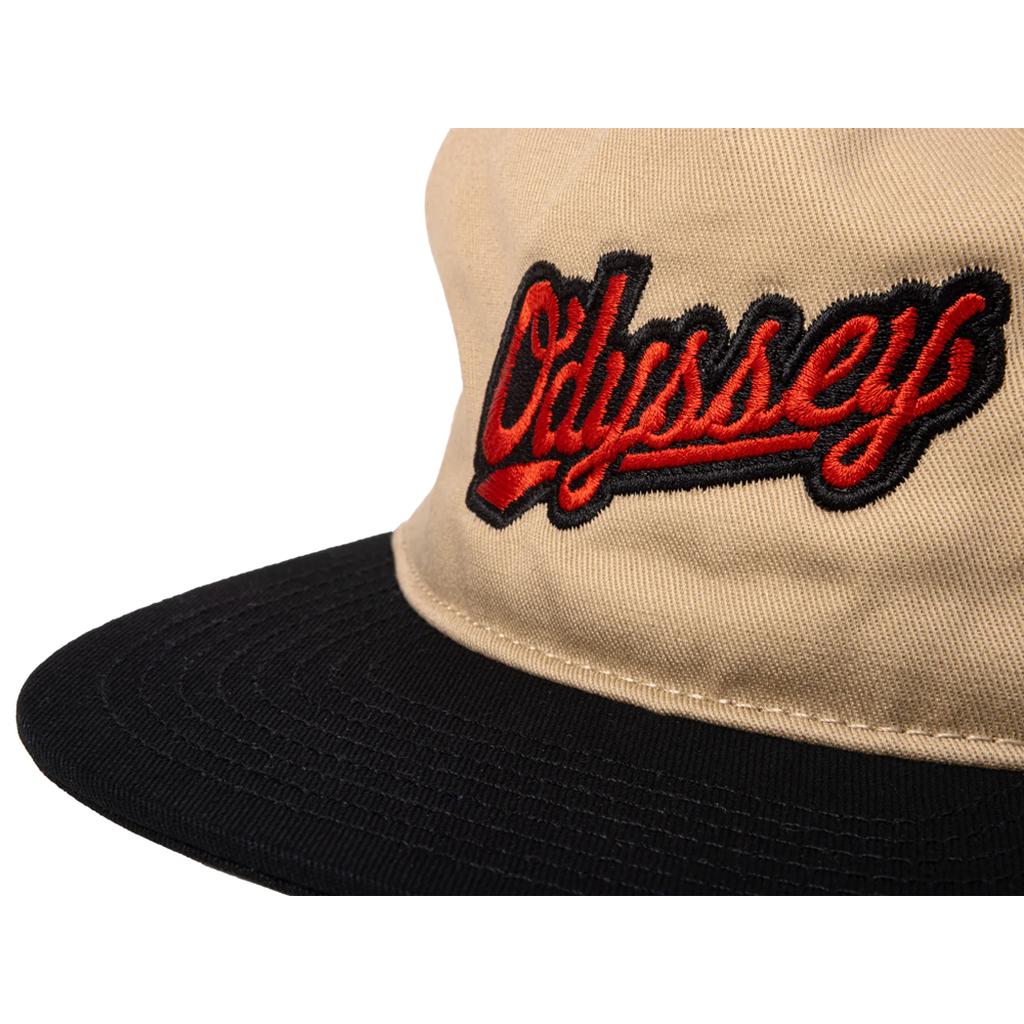 Close-up of the Odyssey Slugger Cap in beige and black, featuring "Odyssey" embroidered in red and black on the front, from our holiday collection with the iconic Slugger logo.