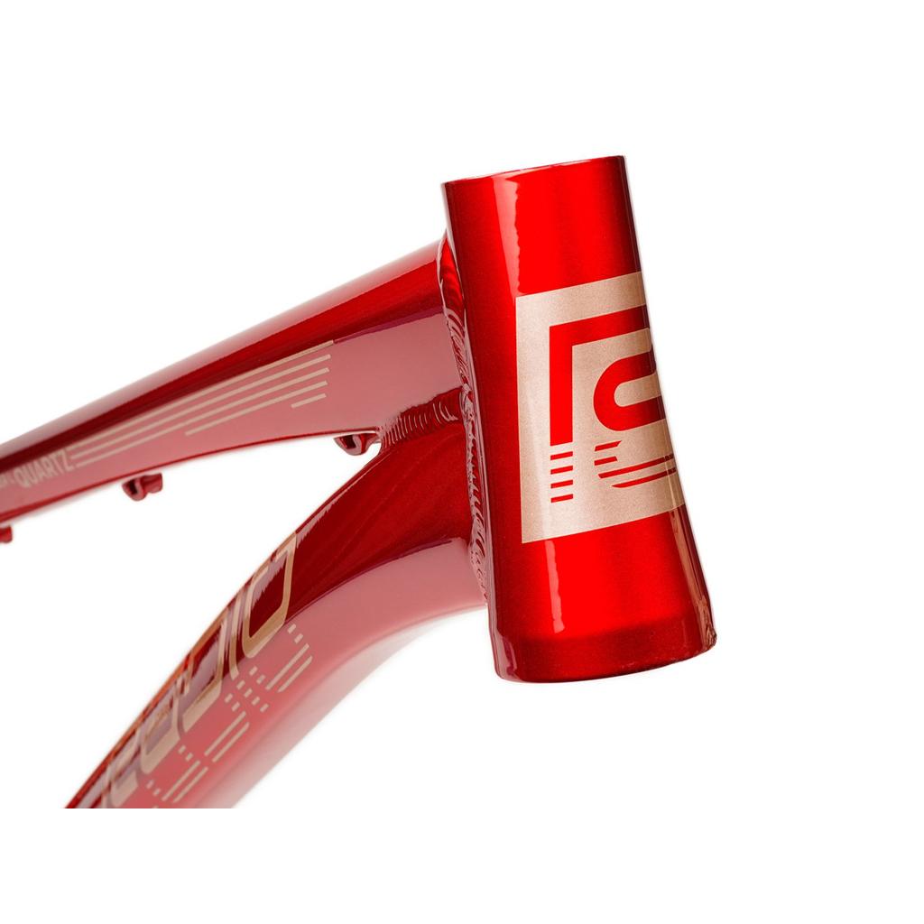 Close-up of the Radio Raceline Quartz 2025 Pro XL Cruiser Frame in red aluminium, highlighting the head tube with a white geometric logo and top/down tubes—ideal for BMX racing with a sliding dropout disc system.
