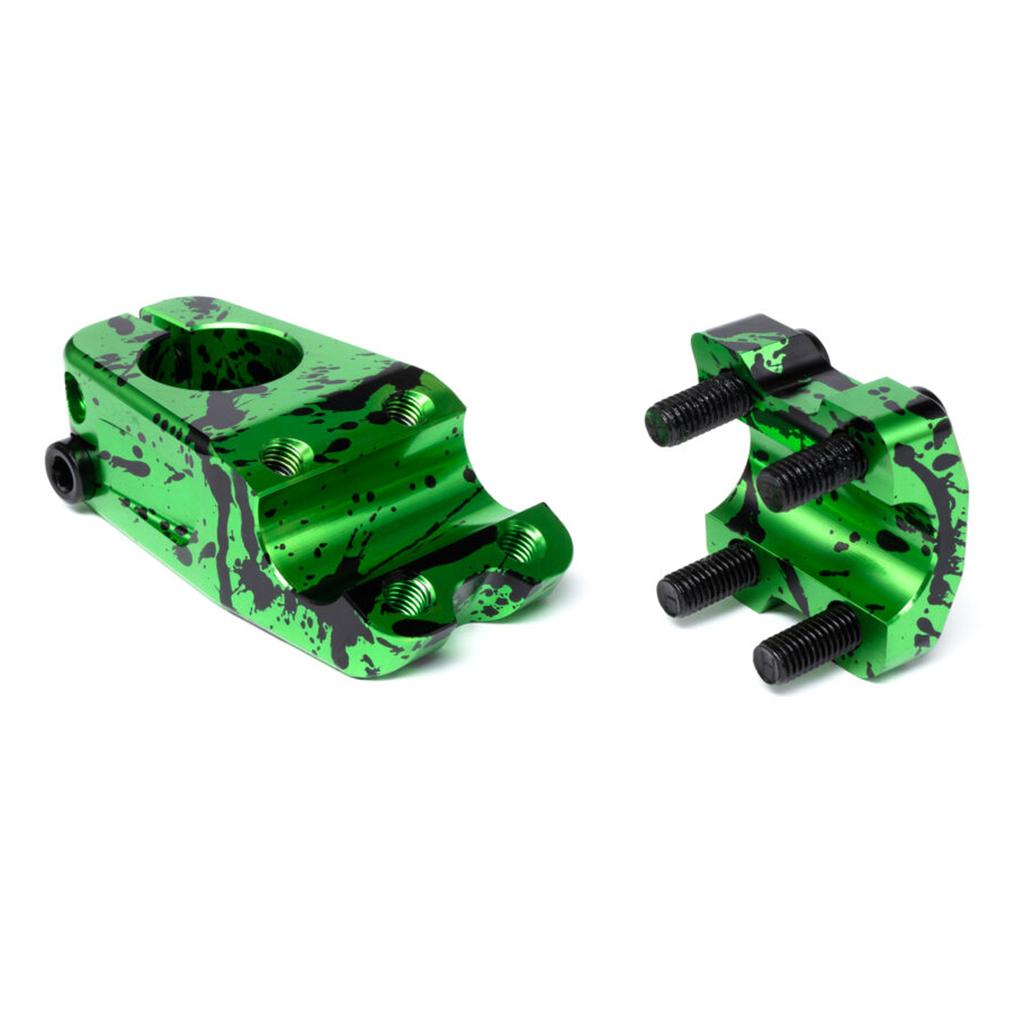 Two Eclat Burns Stem clamps in green and black splatter finish, CNC machined alloy, shown apart with visible bolt holes and screws—a stylish top load bicycle stem design.