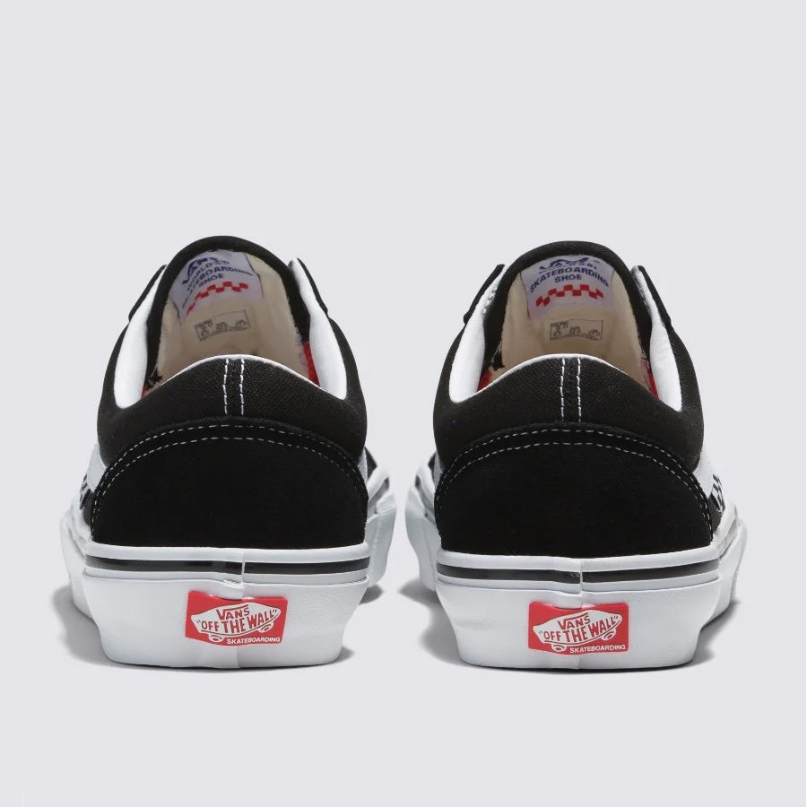 Sentence with product name: Rear view of a pair of black and white Vans Skate Old Skool Shoes - Black/White with red "off the wall" labels on the heel.