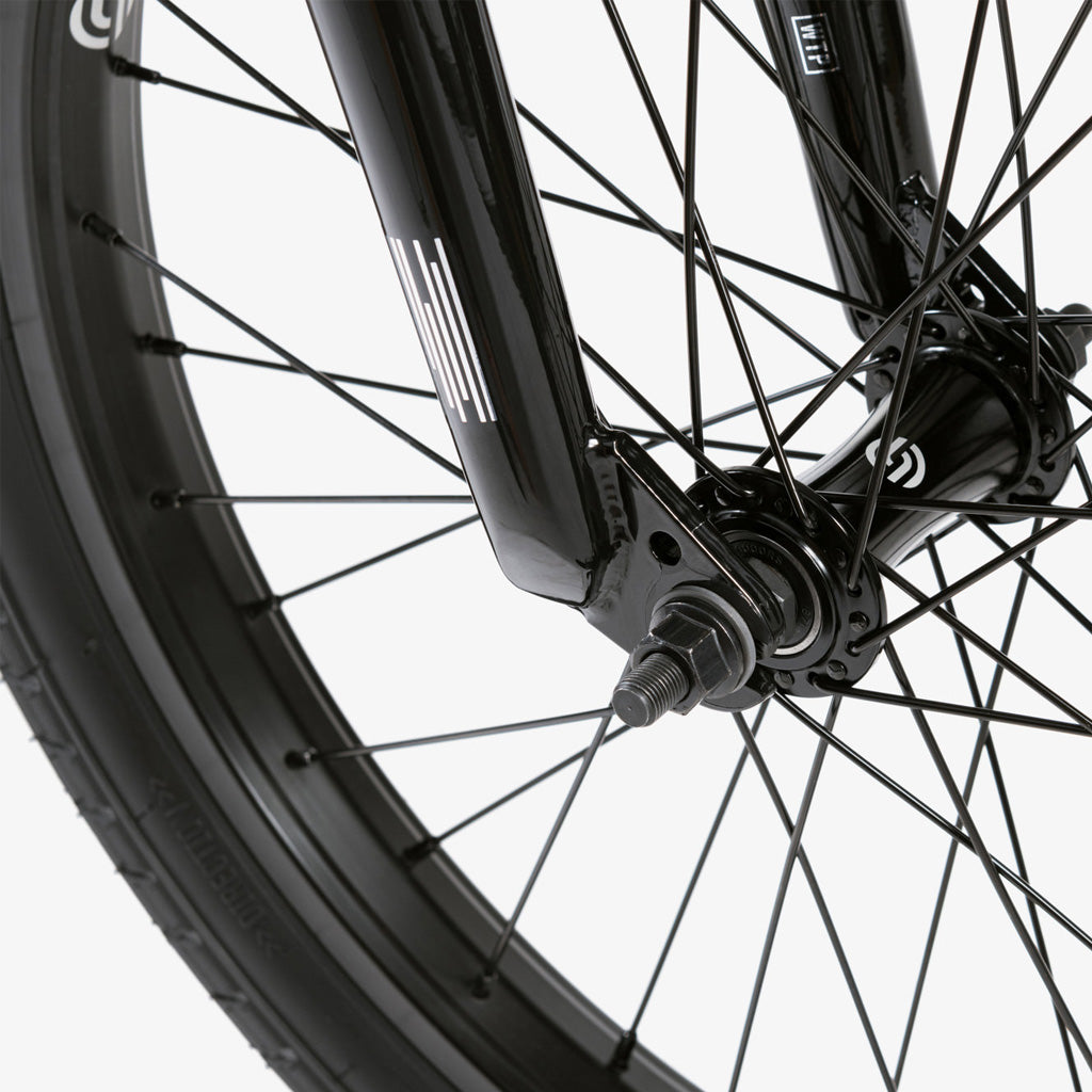 A close up of a black BMX bike wheel featuring the Wethepeople CRS 20 Inch Bike.
