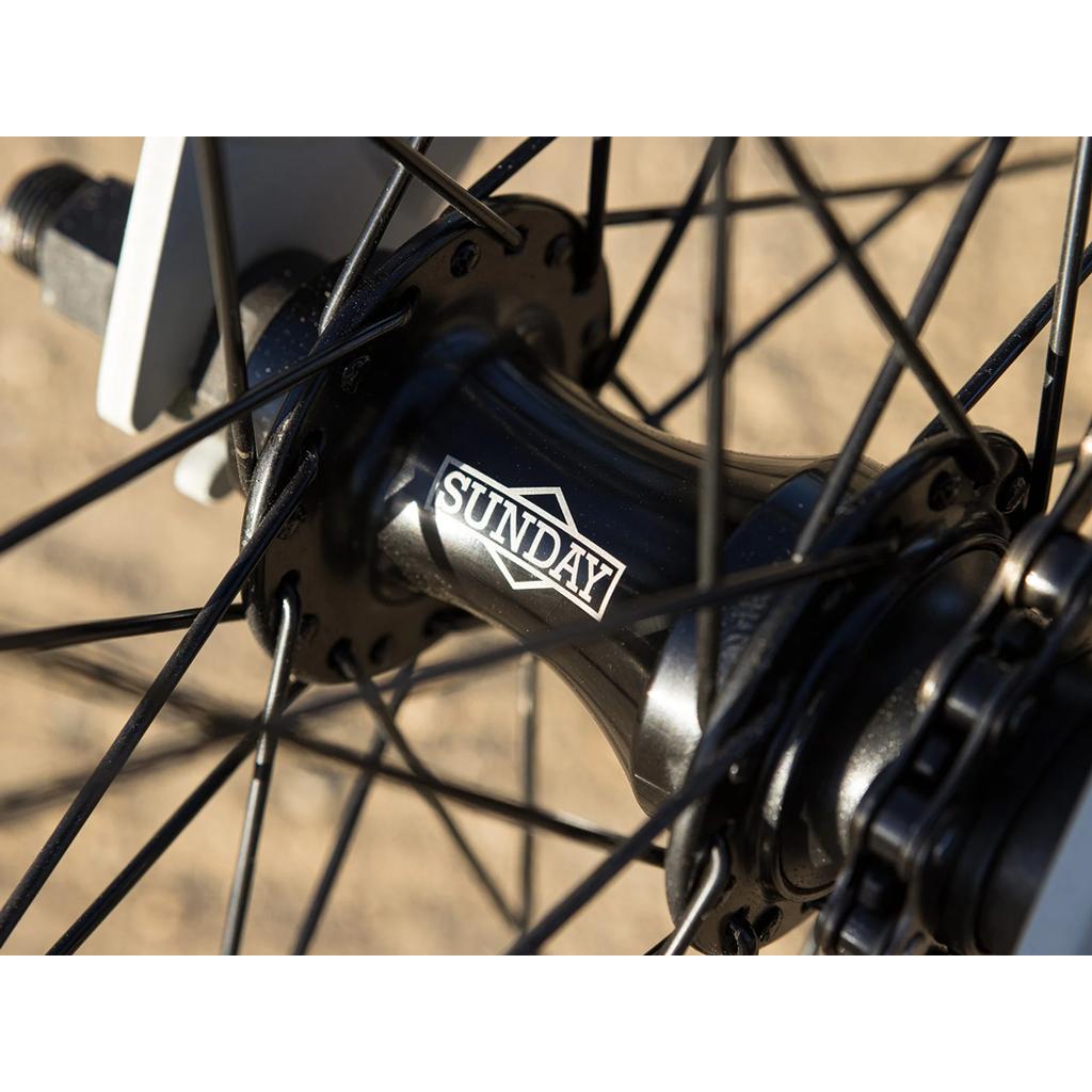 Close-up of a black bicycle hub with "Sunday" branding and black spokes—ideal for 24" BMX builds like the Sunday Model C 24 Inch Bike or any bike with a sturdy chromoly frame.