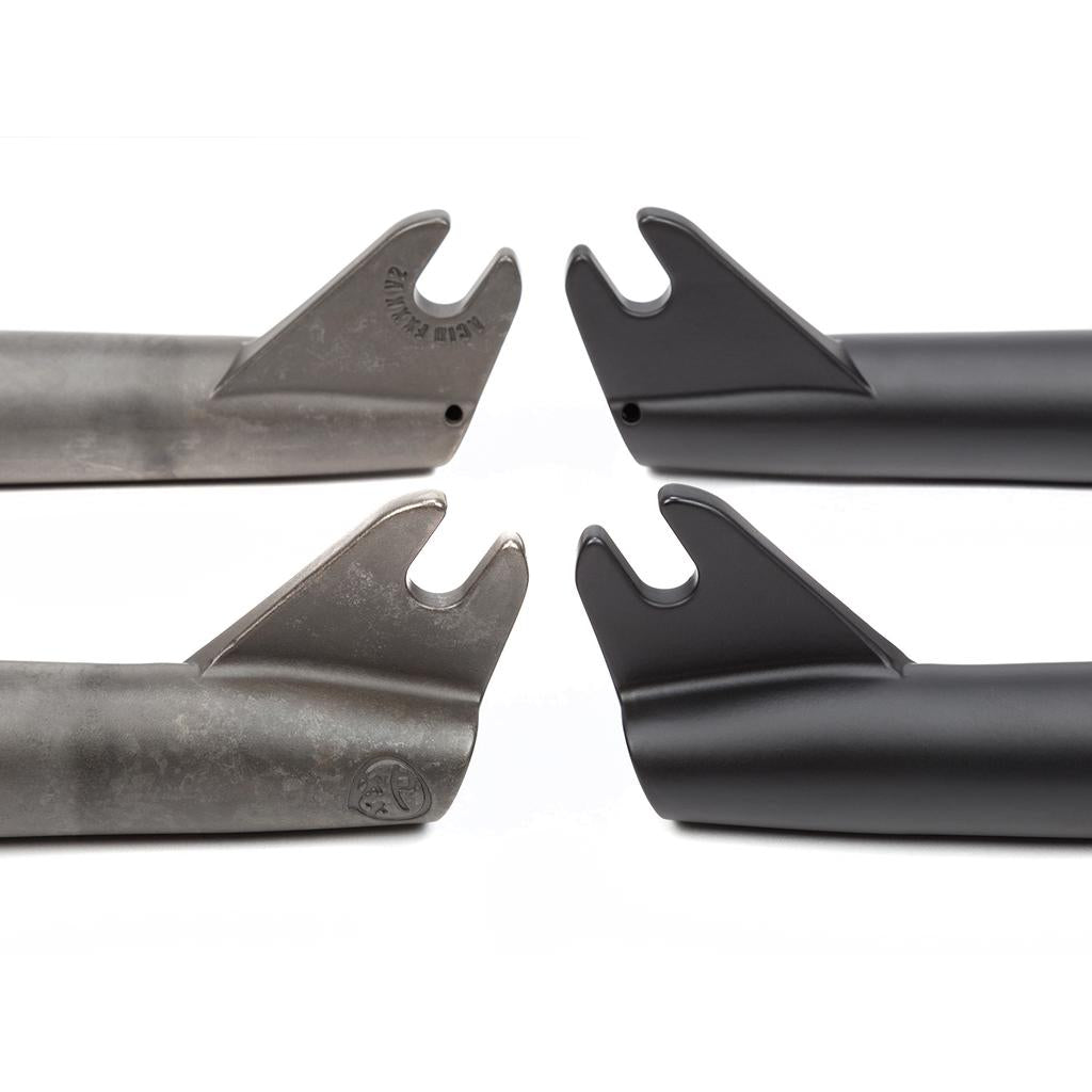 Two pairs of BMX fork dropouts are displayed side by side: one pair is raw 4130 chromoly, while the other is from BSD Acid V2 Forks, finished in sleek black paint.