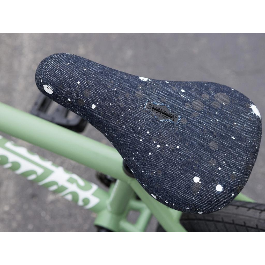 A close-up of a dark, speckled bike seat with white spots on the green Sunday Forecaster 20 Inch Bike (2025) / Brett Silva, featuring a 100% chromoly pro-level BMX frame.