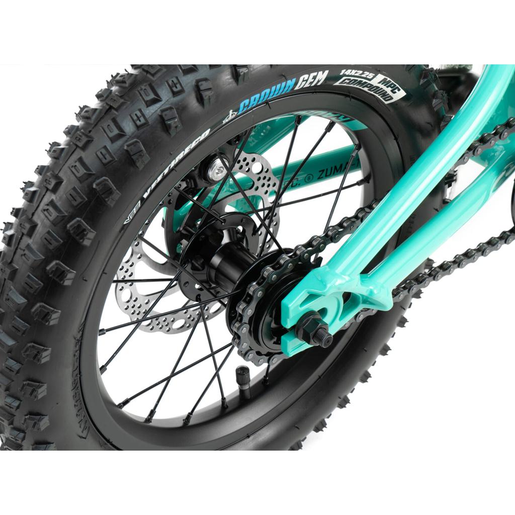 Close-up of the Radio Zuma 14 Inch Bike's rear wheel, highlighting the tire tread, disc brake, spokes, and chain mechanism in a teal kids mountain bike.
