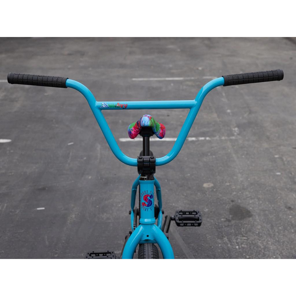 Front view of the Sunday Forecaster 20 Inch Bike (2025) / Aaron Ross in bright blue chromoly, featuring black handlebars, a rainbow seat, and premium Odyssey parts, displayed on a paved surface.