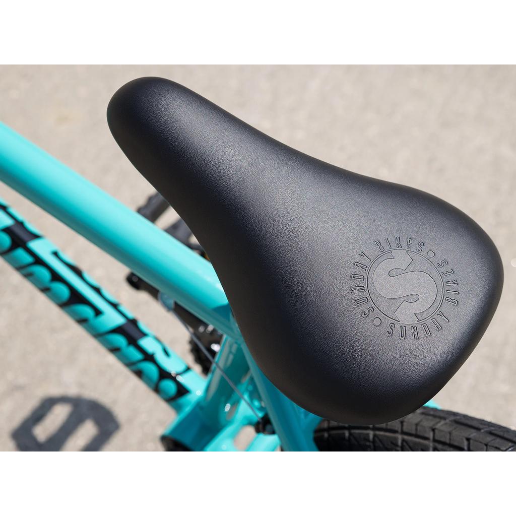 Close-up of a black seat with "Sunday Bikes" logo on a turquoise Sunday Primer 16 Inch Bike (2025), perfect for pro-level BMX riders.