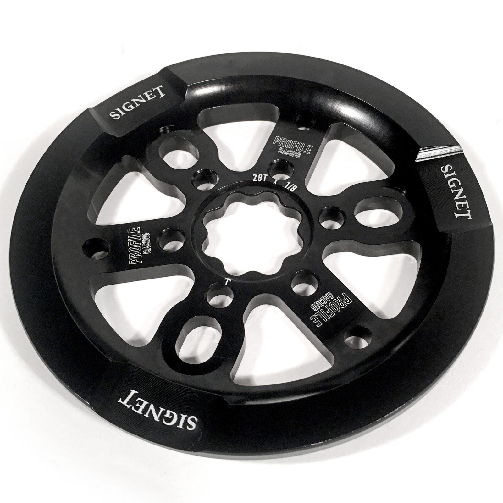 The PROFILE Signet Universal Sprocket W/ guard is a black metal BMX sprocket with "SIGNET" and "PROFILE RACING" branding, multiple cutouts, and a universal guard for broad crank compatibility.