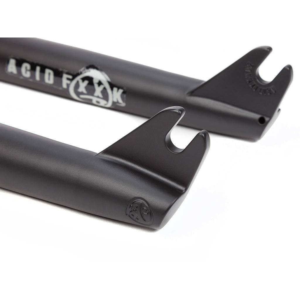 Close-up of two black BSD Acid V2 Fork dropouts with the "ACID FXXX" logo and small graphic engravings, highlighting their detailed design.