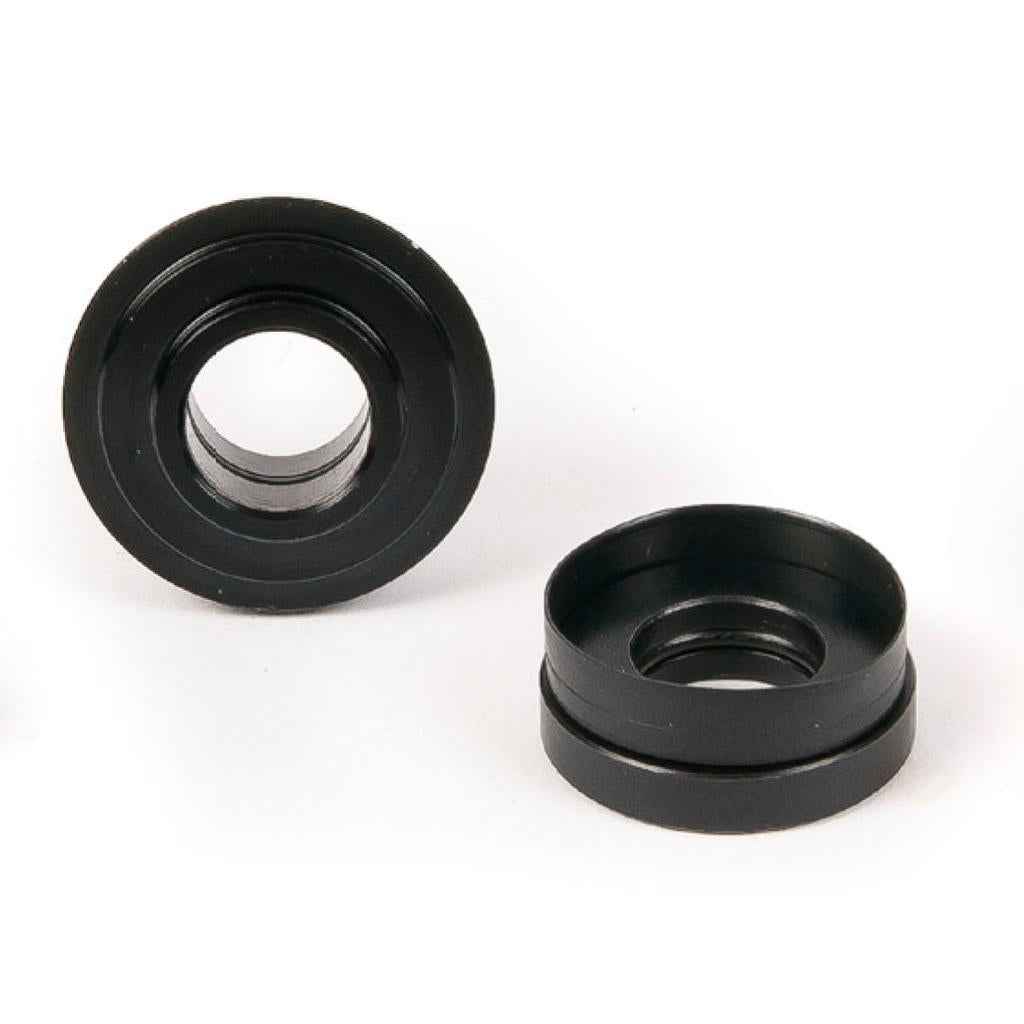 Two black, circular plastic Eclat Dynamic Cone Set grommets—suitable for use with a dynamic rear hub or as replacement cones—are displayed on a white background, one upright and one lying flat.
