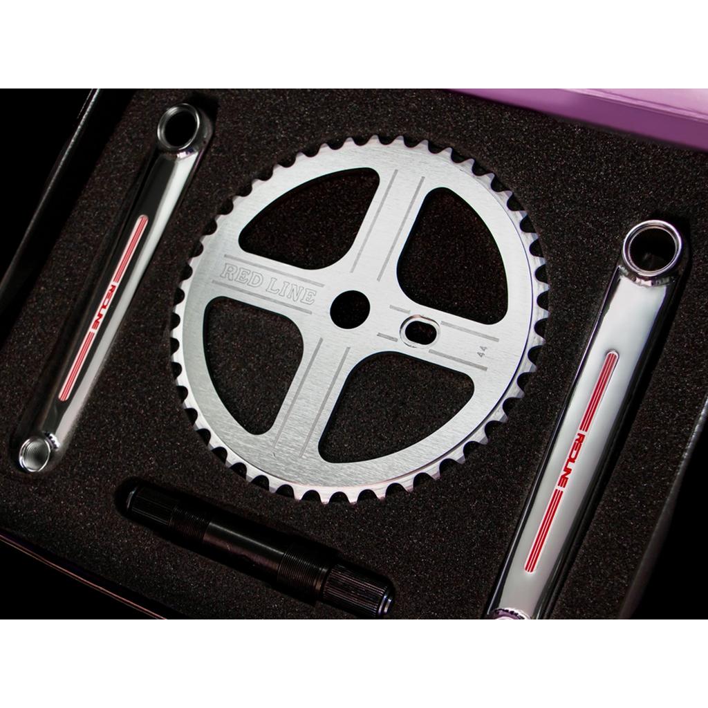The Redline Vintage Flight 401 Pinchless Crank Set, featuring a silver chainring, two crank arms, and a spindle from 1980s BMX racing heritage, is displayed in black foam packaging.