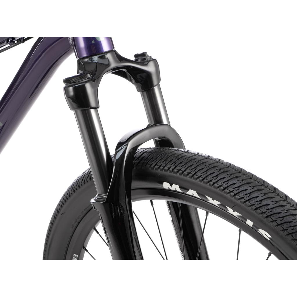 Close-up of the Radio Griffin 26 Inch Bike’s front fork and wheel, highlighting its suspension fork, Tektro disc brakes, and Maxxis DTH tire branding.