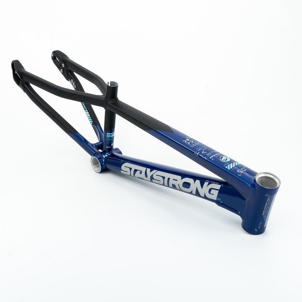 The Staystrong V5 Disc Junior Frame, in blue and black with "STAYSTRONG" branding, is an aluminium race frame designed for disc brake compatibility and shown on a white background.