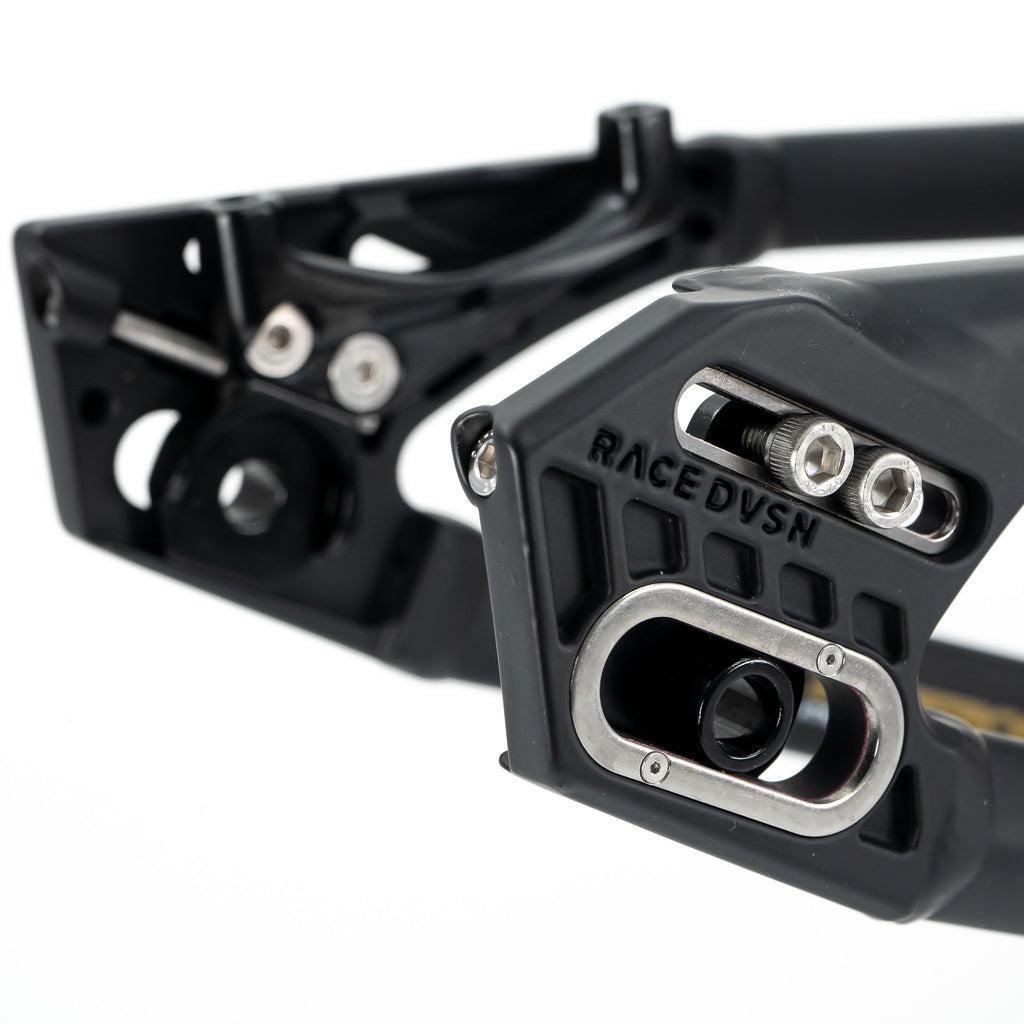 Close-up of black metal dropouts with adjustable inserts and bolts on the Staystrong V5 Disc Expert XL Cruiser Frame, featuring "RACE DVSN" engraved—showcasing advanced Stay Strong aluminium race frame engineering.