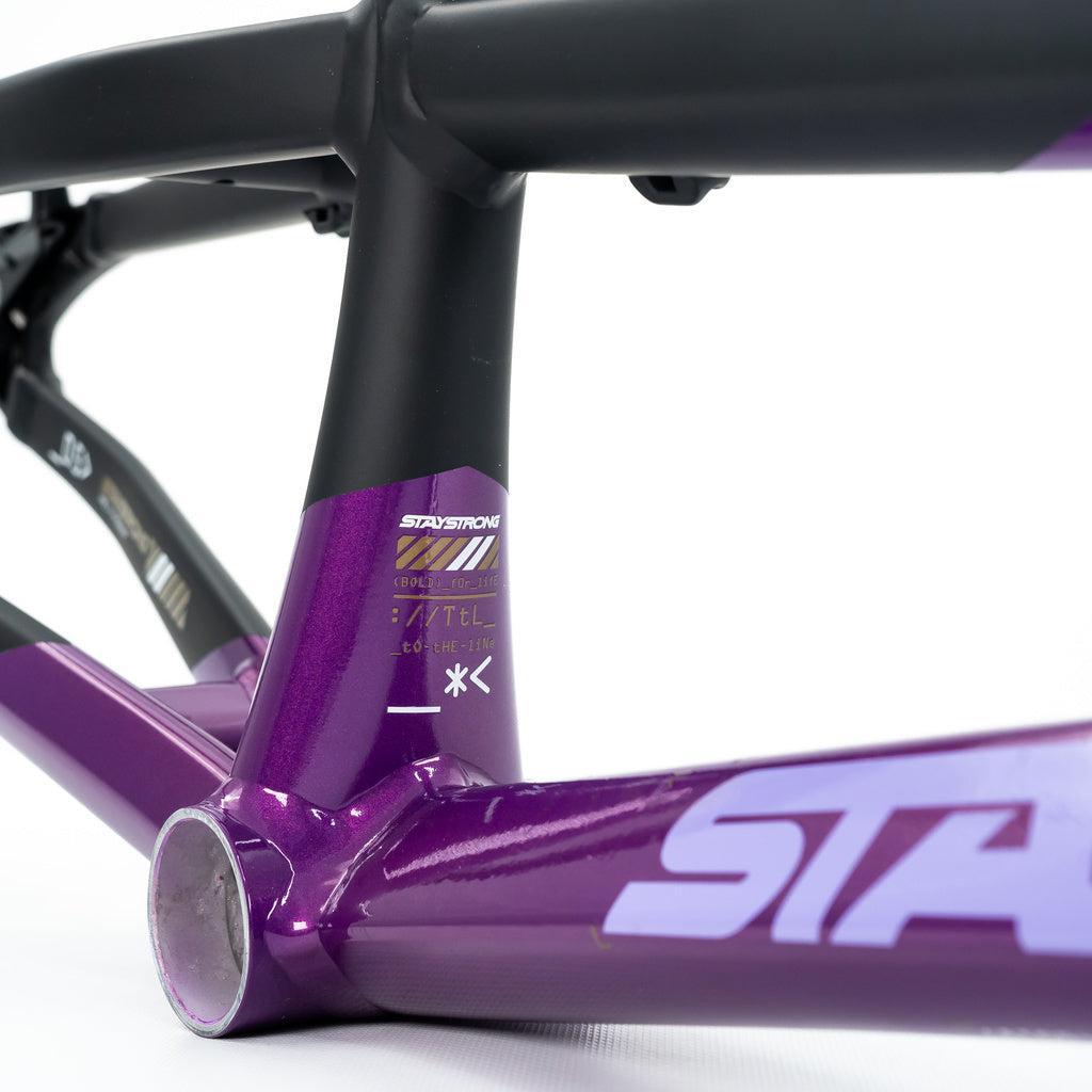 Close-up of the Staystrong V5 Disc Expert XL Cruiser Frame in purple and black, focusing on the bottom bracket and seat tube with branding and decals on this aluminium race frame.