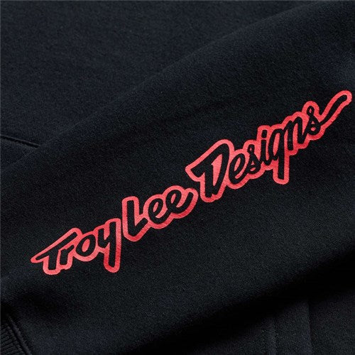 The TLD 26.1 Pullover Hoodie Badge Black features "Troy Lee Designs" in red stylized script on black fabric—ideal for staying warm and showcasing Troy’s iconic style.