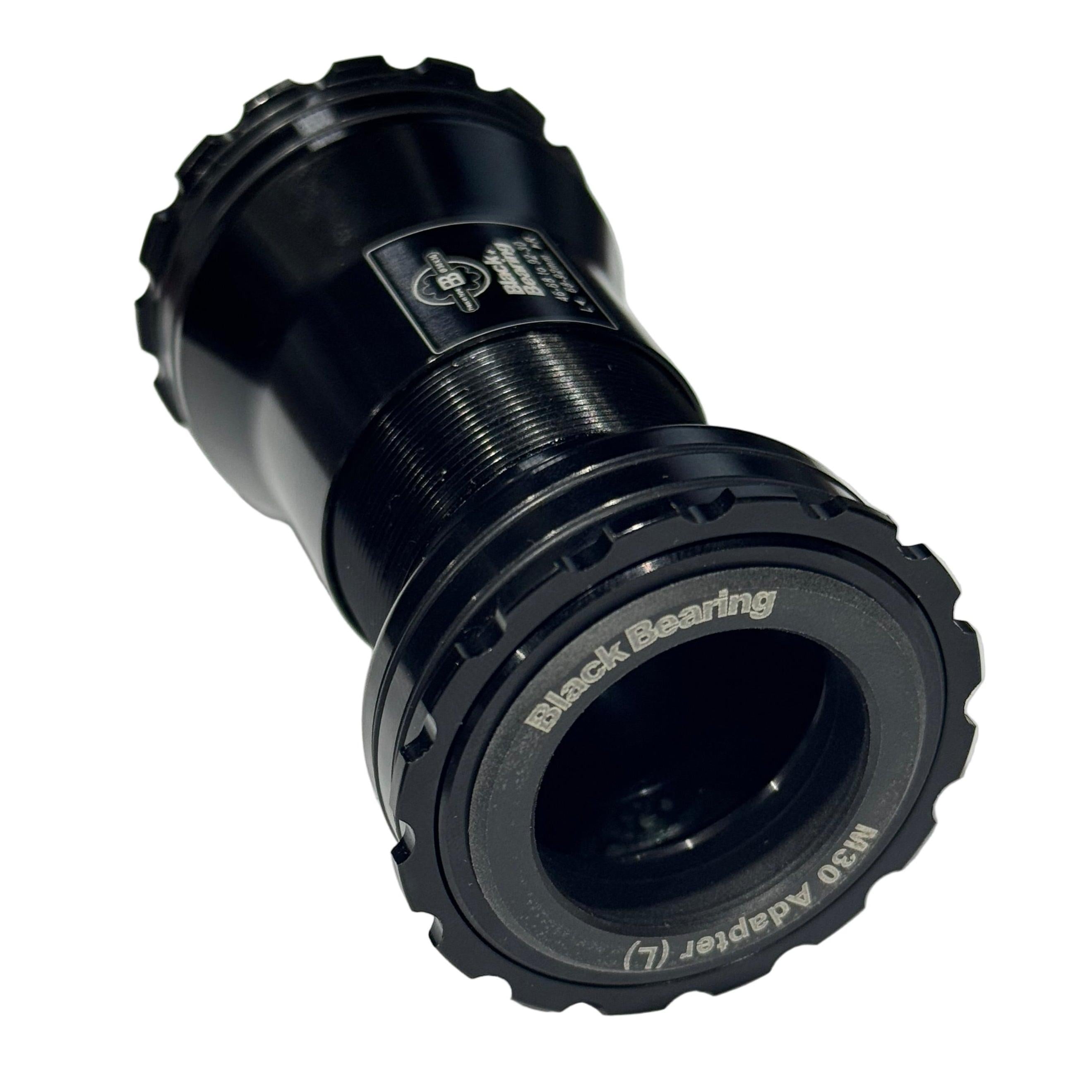 The Black Bearing B5 BB386 EVO M30 Praxis Bottom Bracket is a black CNC-machined aluminum adapter with textured edges, labeled text, and BBlock technology, shown on a white background.