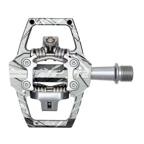 Close-up view of HT T2-SX Clip In Pedals, highlighting the clipless mechanism and CNC machined chromoly spindle in a silver and gray striped design.