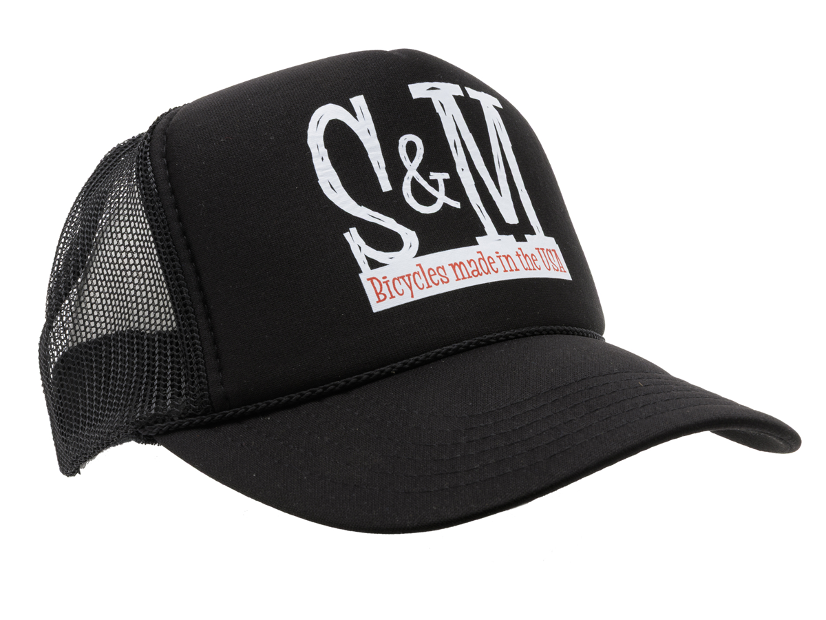 The S & M Scratch Tall Trucker Cap is a black high crown cap with a mesh back, featuring “S&M” in large white letters and “Bicycles made in the USA” in red text on the front.