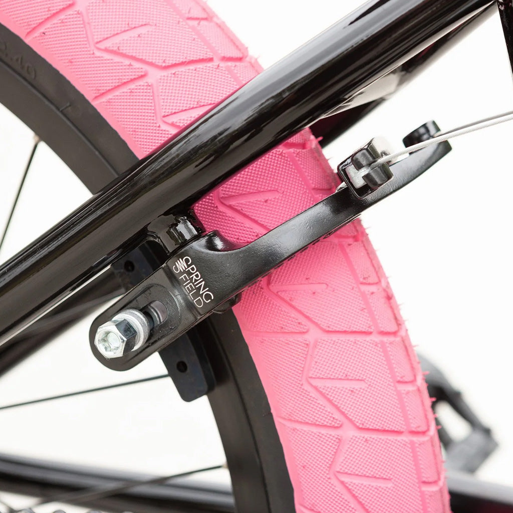 A close up of a Sunday Blueprint 20 inch Bike with a pink tire.
