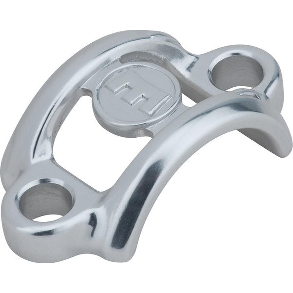 The Magura MT-C Clamp is a polished metal replacement with two mounting holes, a raised central section, and a circular emblem featuring two parallel lines—ideal for Magura MT-C brake levers.