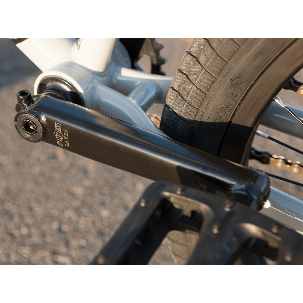 Close-up of the crank arm on a Sunday EX Erik Elstran 20 Inch Bike’s chromoly frame, showing part of the pedal and tire.