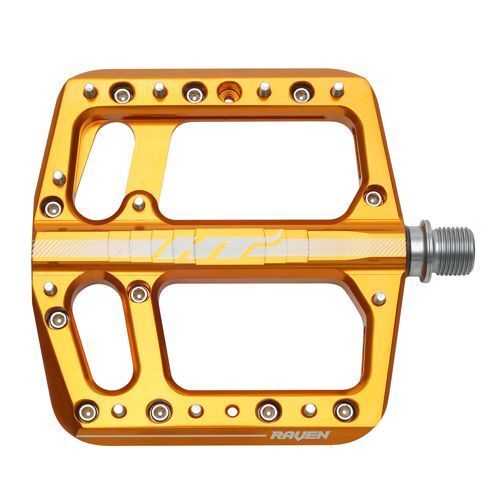 The HT Components ANS12 Raven Pedals are orange aluminum mountain bike pedals with a flat, rectangular design, multiple grip pins, and the "RAVEN" label, displayed against a white background.
