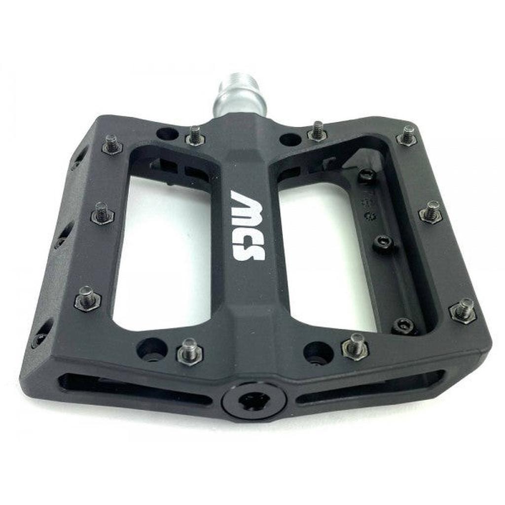 The MCS Sealed Pedals are black flat BMX pedals featuring metal pins, white "MCS" lettering, and a durable thermoplastic nylon body for reliable performance.