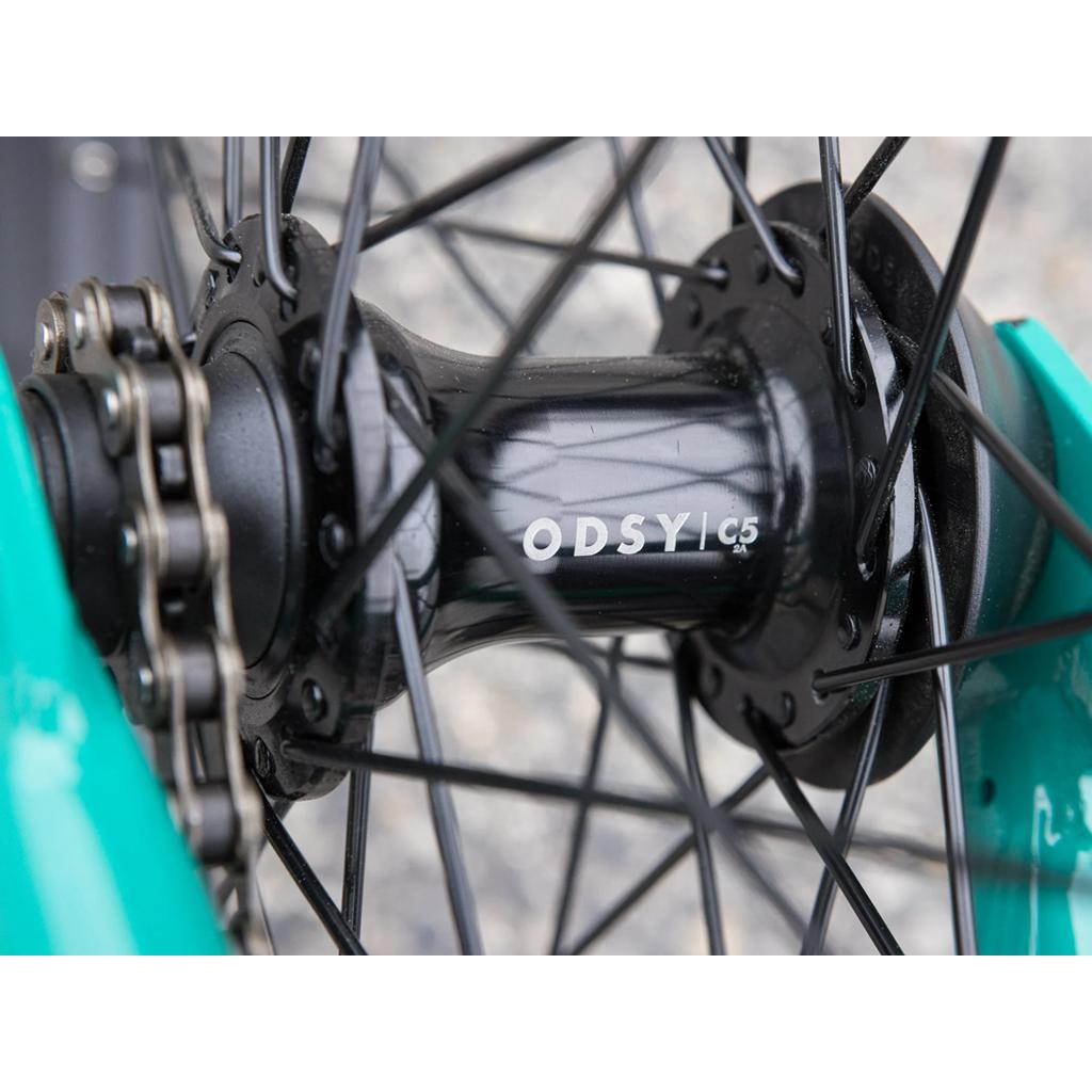 Close-up of a Sunday EX Erik Elstran 20 Inch Bike wheel hub marked "ODSY C5," with black spokes, turquoise Chromoly frame, and visible chain mechanism, highlighting quality Odyssey components.
