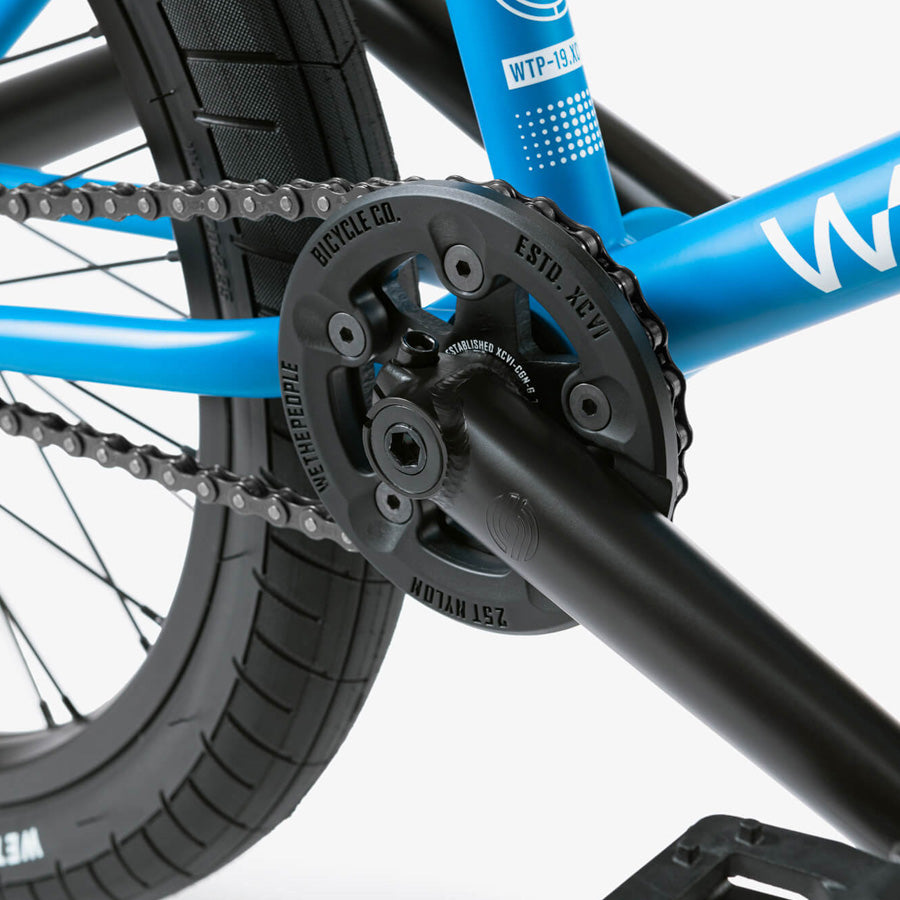 A close up of a blue Wethepeople Reason 20 Inch BMX Bike with a chain.
