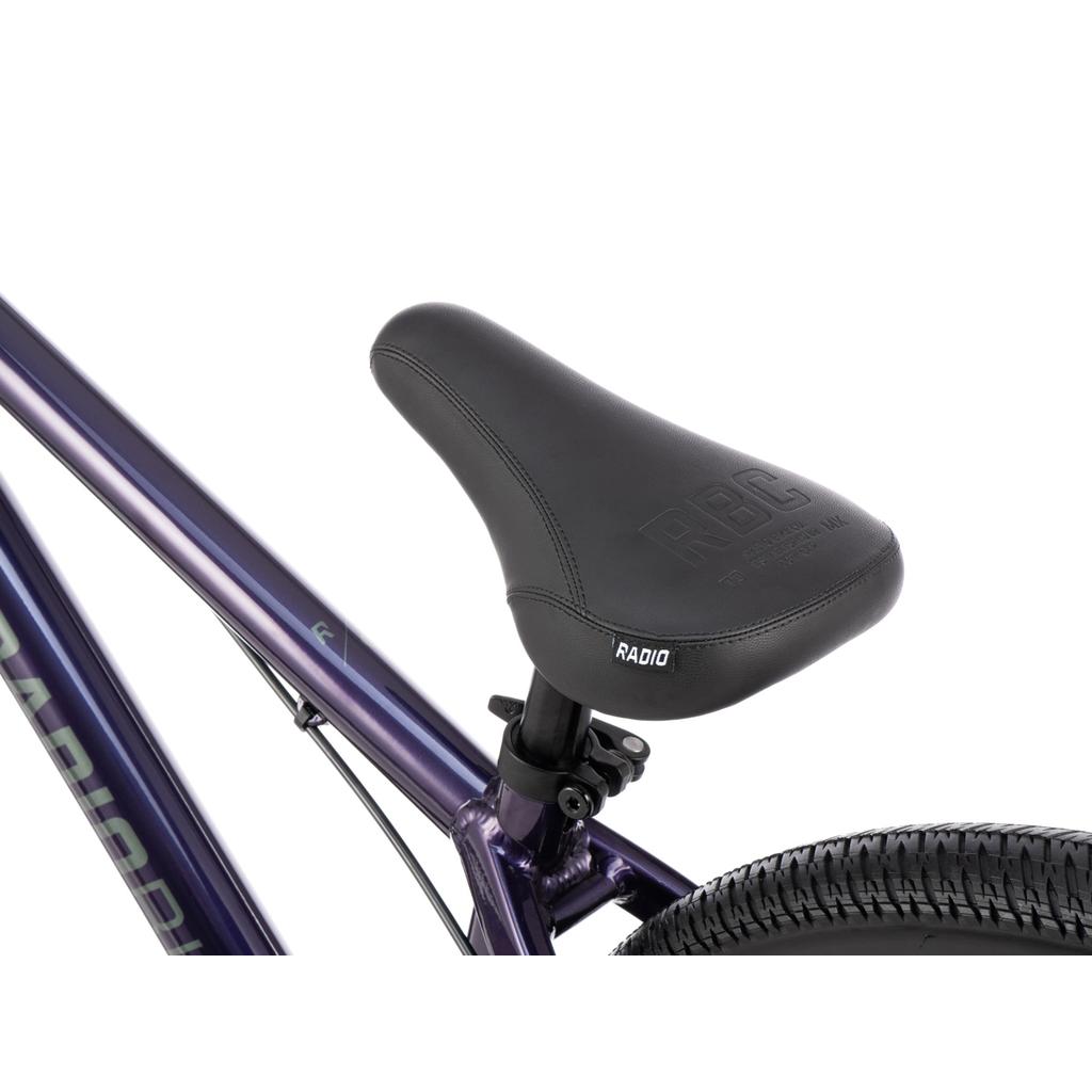 Close-up of a black bicycle seat attached to a metallic purple Radio Griffin 26 Inch Bike frame, with part of the rear tire and seat post visible.